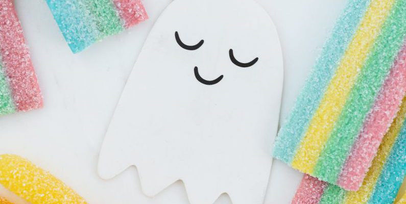 Ghost - Lots of Candies Scattered Around a Cute Ghost Paper Cutout
