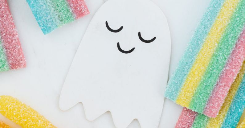 Ghost - Lots of Candies Scattered Around a Cute Ghost Paper Cutout