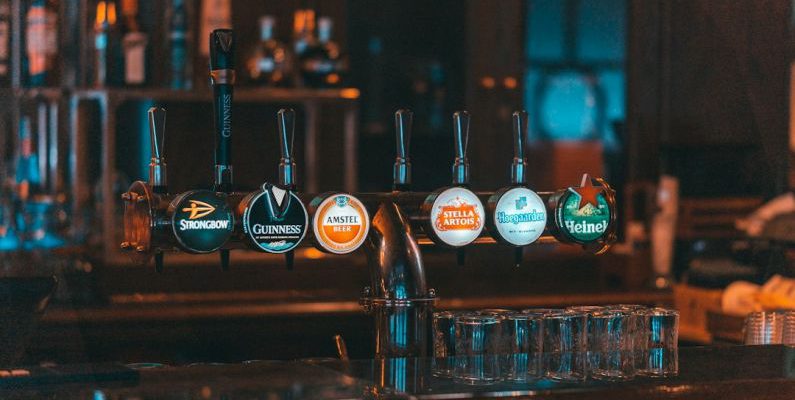Speakeasies - a row of beer taps sitting on top of a bar