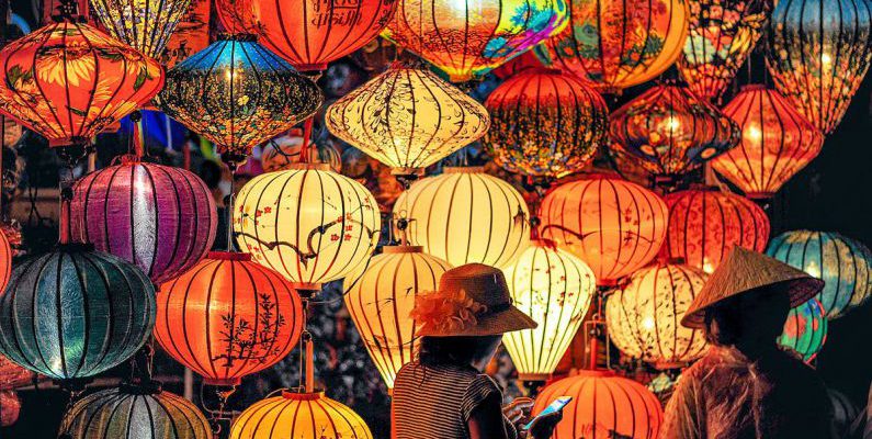 Culture - Two Person Standing Near Assorted-color Paper Lanterns
