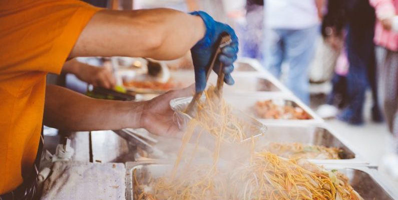 Street Food - Person in Orange Shirt Holding Aluminum Rectangular Container