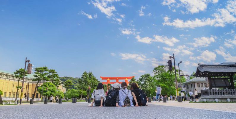 Day Tour - Four Girl's Sitting on Gray Concrete Floor Under Blue Sky