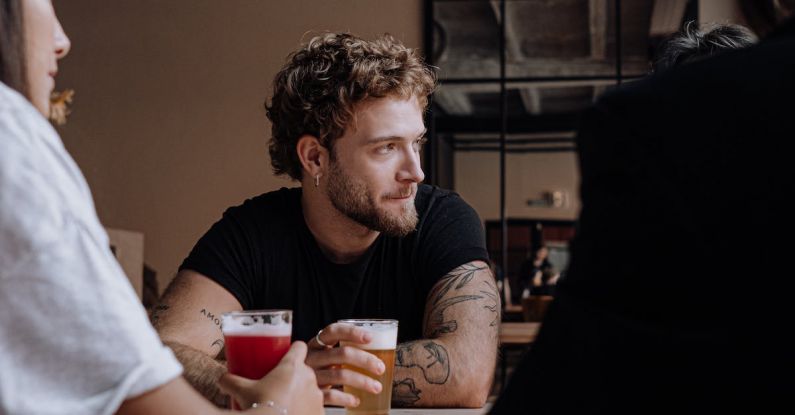 Beer - Photo of a Man with Curly Hair Holding a Glass of Beer