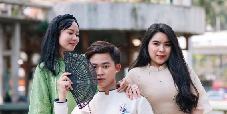 Family-Friendly - Three asian people posing for a photo with a fan