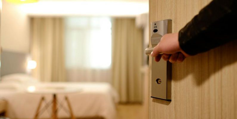 Hotels - Person Holding on Door Lever Inside Room